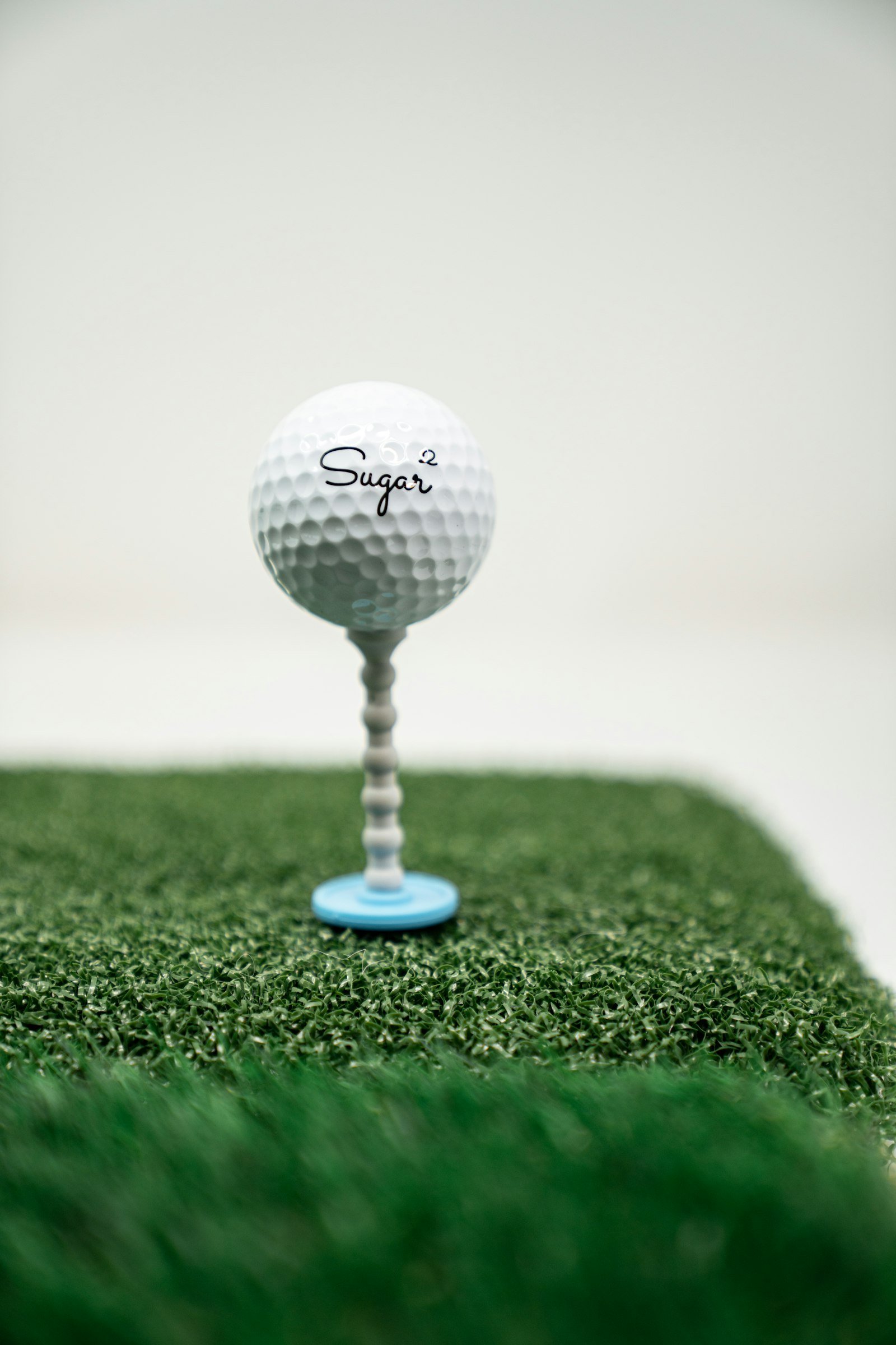 A single white golf ball resting on bright green grass.