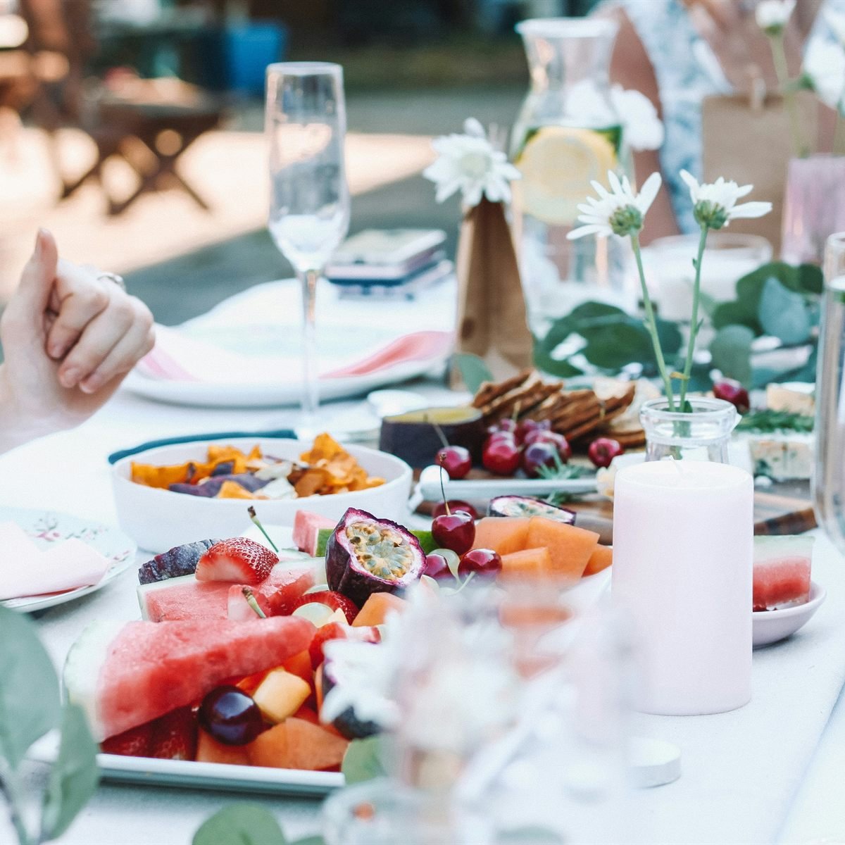 An outdoor table laid with breakfast, fruit and glasses of sparkling wine.