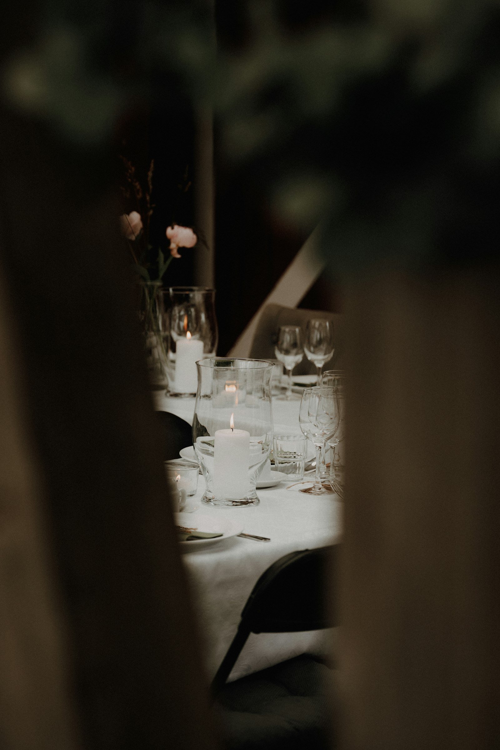 A long dinner table set with candles and glassware.