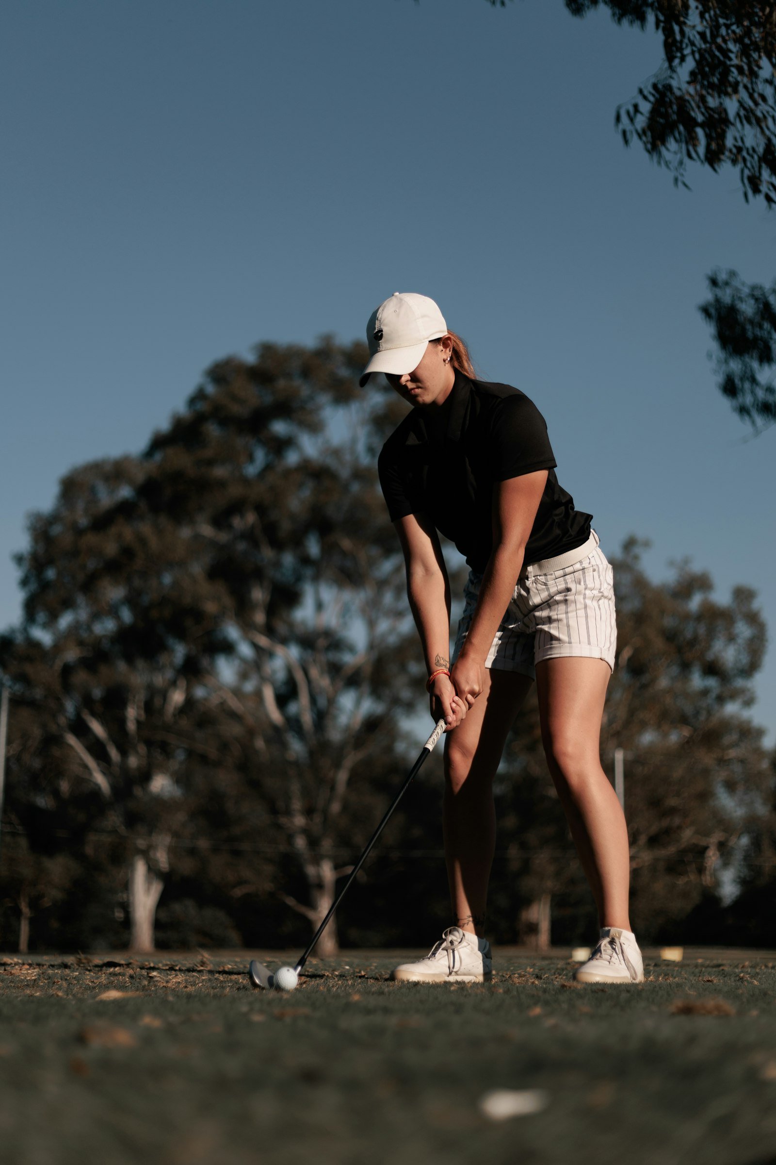 A golfer lining up a shot from the tee box.