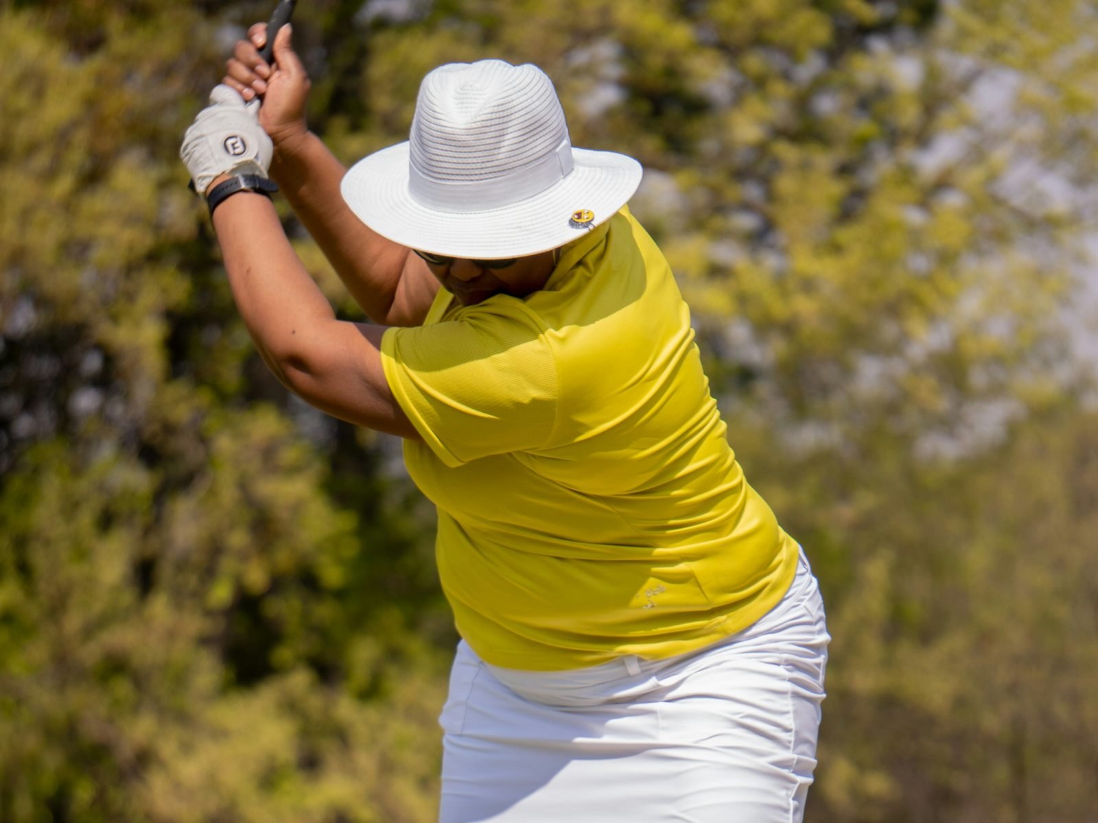 A woman at the top of her backswing on the tee.