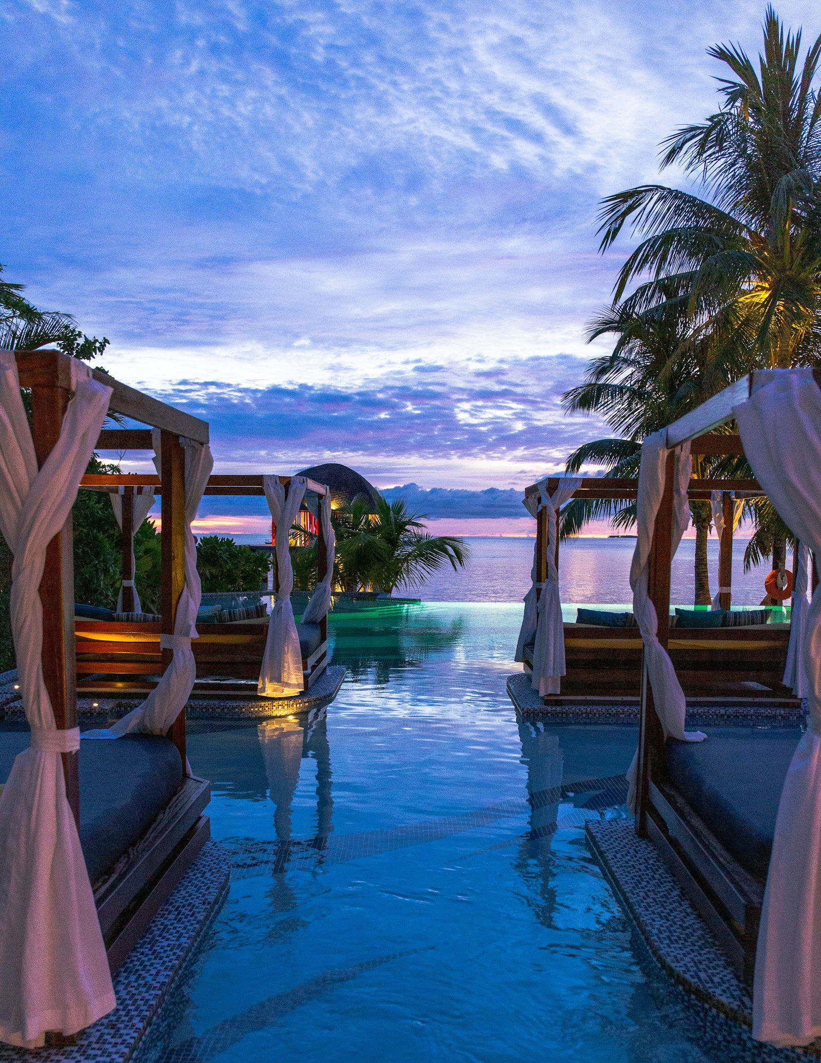 A cliffside resort terrace overlooking open blue water.