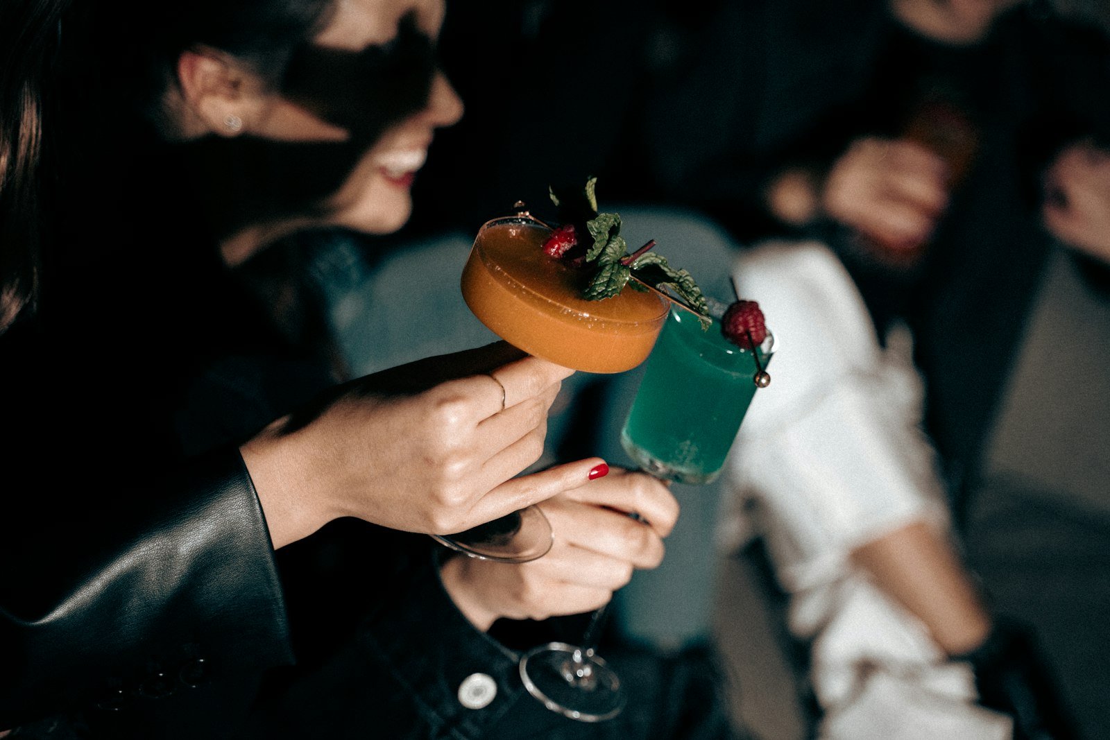 A hand holding a garnished cocktail.
